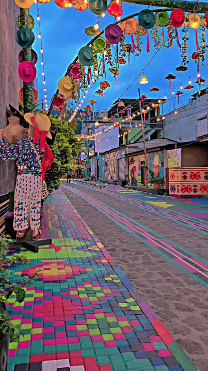 Calle colorida decorada con sombreros y luces