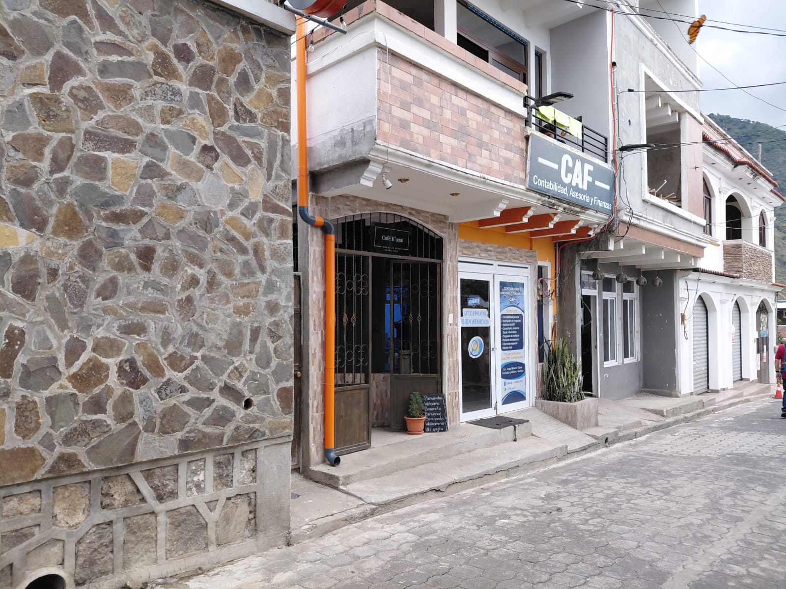 Fachada de la oficina CAF sobre calle adoquinada